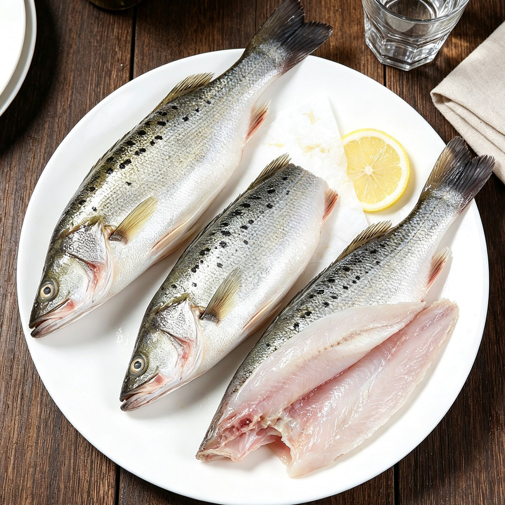 Three whole silver fish and one fillet on a white plate