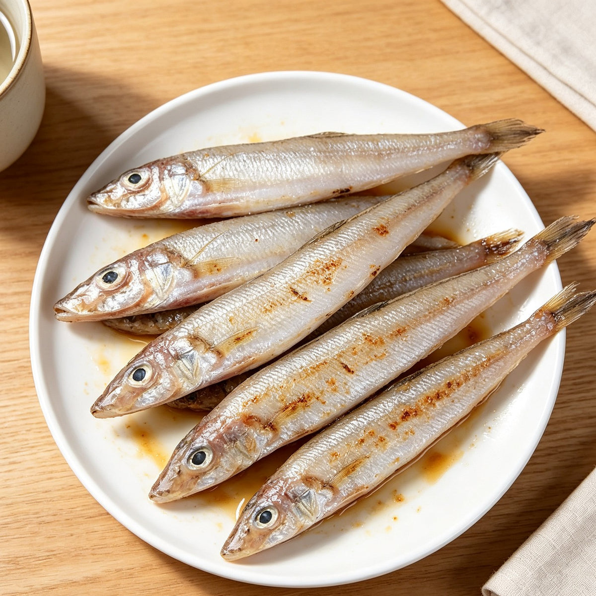 Pan-fried sea smelt arranged on a white plate