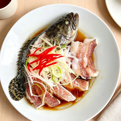 Steamed whole grouper garnished with ginger and chilli
